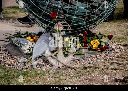 Newhaven, Großbritannien. 28. April 2022. 100 Menschen versammelten sich am Ende des Hafens von Newhaven zur Enthüllung eines Denkmals, das an die auf See verlorenen Fischer erinnert. Die Skulptur, ein kupfergekleideter Schwarm von Fischen, wurde sechs Männern gewidmet, die vor der Küste von Newhaven ihr Leben verloren haben. Die Statue soll ein dynamischer Fischball sein, wie ein Köderball, der sich bildet, wenn er von Delfinen gejagt wird. Das Denkmal befindet sich am Fuße der Fort Road in Newhaven Robert Morleys Familie hat sich für ein permanentes Denkmal für diejenigen eingesetzt, die in den letzten Jahren beim Fischfang vor der küste von sussex ums Leben gekommen sind und mehr Tonnen aufgestachelt haben Stockfoto