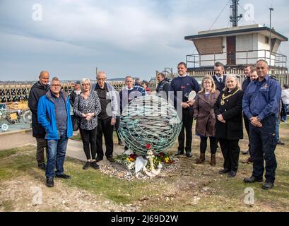 Newhaven, Großbritannien. 28. April 2022. 100 Menschen versammelten sich am Ende des Hafens von Newhaven zur Enthüllung eines Denkmals, das an die auf See verlorenen Fischer erinnert. Die Skulptur, ein kupfergekleideter Schwarm von Fischen, wurde sechs Männern gewidmet, die vor der Küste von Newhaven ihr Leben verloren haben. Die Statue soll ein dynamischer Fischball sein, wie ein Köderball, der sich bildet, wenn er von Delfinen gejagt wird. Das Denkmal befindet sich am Fuße der Fort Road in Newhaven Robert Morleys Familie hat sich für ein permanentes Denkmal für diejenigen eingesetzt, die in den letzten Jahren beim Fischfang vor der küste von sussex ums Leben gekommen sind und mehr Tonnen aufgestachelt haben Stockfoto