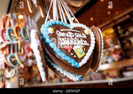 München, Deutschland. 29. April 2022. 29. April 2022, Bayern, München: Lebkuchenherzen mit der Aufschrift „Grüße aus München“ hängen an einem Stand beim Frühlingsfest auf der Theresienwiese. Das Frühlingsfest läuft vom 22,04. Bis 08.05.2022. Foto: Matthias Balk/dpa Quelle: dpa picture Alliance/Alamy Live News Stockfoto