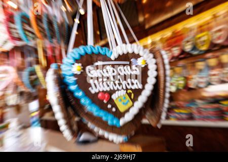 München, Deutschland. 29. April 2022. 29. April 2022, Bayern, München: Lebkuchenherzen mit der Aufschrift „Grüße aus München“ hängen auf einem Stand beim Frühlingsfest auf der Theresienwiese. Das Frühlingsfest läuft vom 22,04. Bis 08.05.2022. (Foto mit Zoom-Effekt) Foto: Matthias Balk/dpa Quelle: dpa picture Alliance/Alamy Live News Stockfoto