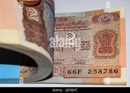 Alte zwei Rupien-Noten auf dem Tisch kombiniert, Indien-Geld auf dem rotierenden Tisch. Alte indische Währung auf einem rotierenden Tisch, indische Währung auf dem Ta Stockfoto