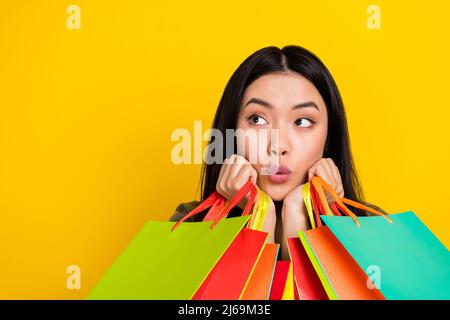 Foto von beeindruckt tausendjährigen Brünette Dame tun Shopping-Look promo isoliert auf gelbem Hintergrund Stockfoto