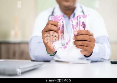 Nahaufnahme des Arztes, der Geld in der Klinik zählt - Konzept Profit, Korruption und Bestechung Stockfoto