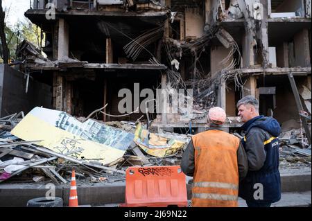 Kiew, Ukraine. 29. April 2022. 29. April 2022, Kiew, Kiew, Kiew, Ukraine: Arbeiter vor dem zerstörten Gebäude. Während die Retter nach Menschen suchen, reinigen die Arbeiter das Gebiet und treffen am 28.. April ein Gebäude im Schevchenko-Bezirk in Kiew (Kiew), nachdem Raketen das Gebäude getroffen haben. Fast ein Dutzend Menschen wurden verletzt, und Vera Gyrych, Journalistin von Radio Liberty, starb. (Bild: © Valeria Ferraro/ZUMA Press Wire) Bild: ZUMA Press, Inc./Alamy Live News Stockfoto