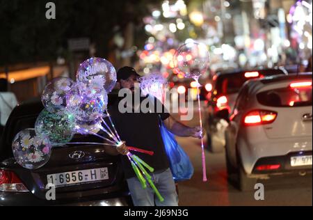 (220429) -- RAMALLAH, 29. April 2022 (Xinhua) -- Ein palästinensischer Händler verkauft Ballons auf einem Markt vor dem Eid al-Fitr-Festival in der Stadt Ramallah im Westjordanland, am 28. April 2022. (Foto von Ayman Nobani/Xinhua) Stockfoto