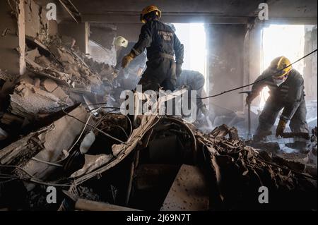 Kiew, Ukraine. 29. April 2022. 29. April 2022, Kiew, Kiew, Kiew, Ukraine: Retter haben gesehen, wie sie zwischen Staub und Steinen arbeiteten. Während die Retter nach Menschen suchen, reinigen die Arbeiter das Gebiet und treffen am 28.. April ein Gebäude im Schevchenko-Bezirk in Kiew (Kiew), nachdem Raketen das Gebäude getroffen haben. Fast ein Dutzend Menschen wurden verletzt, und Vera Gyrych, Journalistin von Radio Liberty, starb. (Bild: © Valeria Ferraro/ZUMA Press Wire) Bild: ZUMA Press, Inc./Alamy Live News Stockfoto