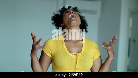 Verärgerte schwarze Frau, die zum Himmel schreit. Wütender afroamerikanischer Mensch, der schreit Stockfoto