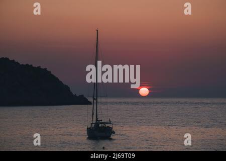 Segelboot gegen Sonnenuntergang in Petani Strand, Kefalonia, Ionisches Meer Stockfoto