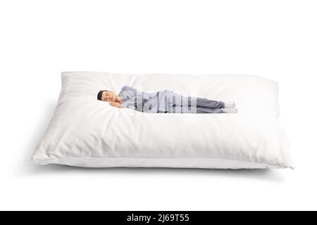 Kerl in Schlafanzug schlafen auf einem großen weichen Kissen isoliert auf weißem Hintergrund Stockfoto