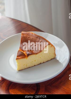 Verbrannter Baskischer Käsekuchen. Ein Stück Käsekuchen mit verbranntem Kuchen Stockfoto