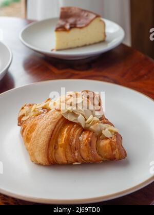 Mandel-Croissant auf dem weißen runden Teller. Stockfoto