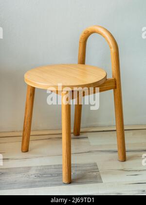 Hocker aus Holz in natürlicher Farbe und schlichtem Design. Stockfoto