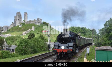 BR Standard Class 4 80104 kommt mit einem Service nach Swanage in Corfe Castle an. Stockfoto