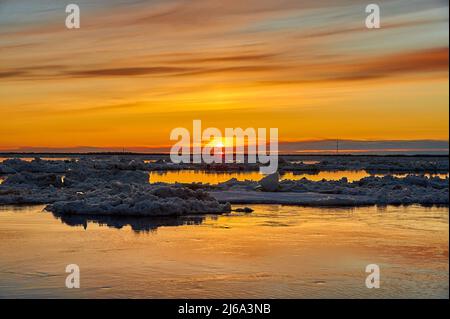 Sonnenuntergang auf dem Fluss während einer Eisdrift Stockfoto