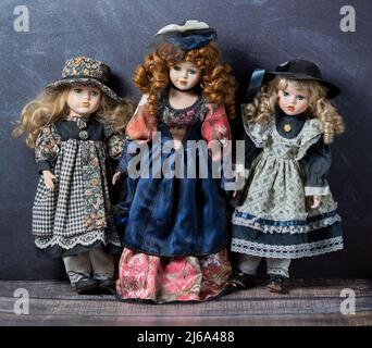 Erstaunlich realistische Vintage 3 Spielzeug mit blauen und grünen Augen.die Puppen in einem schönen farbigen Kleidern gekleidet. Selektiver Fokus. Porzellanpuppen. Stockfoto