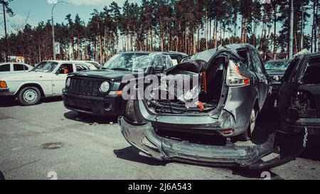 Irpin, Region Kiew, Ukraine - 28. April 2022: Autofriedhof in Irpin, Folgen des Einmarschs der russischen Armee in die Ukraine. Zerstörte Autos von c Stockfoto