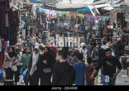 Gaza, Palästina. 29. April 2022. 29. April 2022, Palästinensische Gebiete, Jabalya: Palästinenser kaufen auf einem lokalen Markt ein, bevor die Eid al-Fitr-Feierlichkeiten zum Ende des heiligen muslimischen Fastenmonats Ramadan stattfinden. Foto: Mohammed Talatene/dpa Kredit: dpa picture Alliance/Alamy Live News Stockfoto