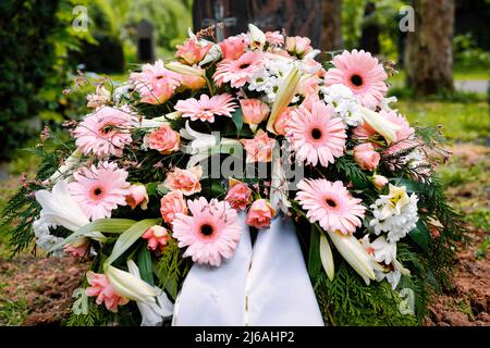 Bunte Pastellblumen auf einem Grab nach einer Beerdigung Stockfoto