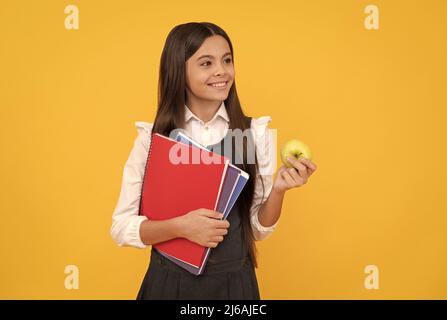 Willkommen zurück in der Schule. Glückliches Kind lächelt mit Apfel und Büchern. Zurück zur Schule. Back-to-School Stockfoto