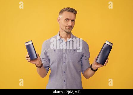 Guy wählen Shampoo-Flasche oder Haarspülung. Tägliche Gewohnheiten und persönliche Pflege. Stockfoto