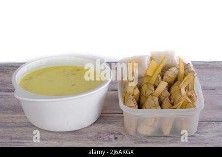 Ketupat & Lodeh . Traditionelles festliches Gericht aus Reiskuchen mit mehreren Beilagen, das während der Eid-Feierlichkeiten im Volksmund serviert wird Stockfoto