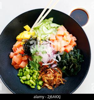 japanische Spezialität, Poke-Schüssel mit Lachs, Gemüse und Reis Stockfoto