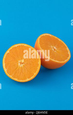 Zwei orangefarbene Nabelhälften auf blauem Hintergrund Stockfoto