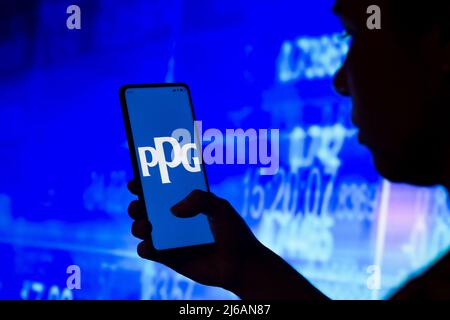 29. April 2022, Brasilien: In dieser Fotolabbildung hält eine Frau mit Silhouetten ein Smartphone, auf dem das Logo von PPG Industries auf dem Bildschirm angezeigt wird. (Bild: © Rafael Henrique/SOPA Images via ZUMA Press Wire) Stockfoto