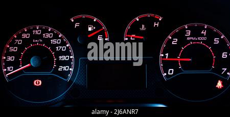 Armaturenbrett des Fahrzeugs. Instrumententafel mit Tachometer, Drehzahlmesser, Kraftstoffanzeige, Öltemperatur, Sicherheitsgurt mit rotem Pfeil auf Schwarz Stockfoto