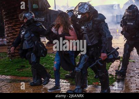 Während der Demonstration wird ein Protestler von der Polizei von Riot verhaftet. Studenten kolonierten heftig mit der Bereitschaftspolizei an der Universität Bogotá, als sie zum Gedenken an den Tag marschierten, an dem der Nationale Streik 2021 in Kolumbien begann. Stockfoto