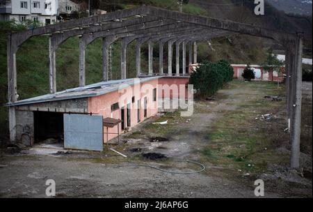 Außenansicht einer alten verlassenen Fabrik aus dem oberen Winkel. Altes Lagerhaus. Heruntergekommenes Industriegebäude Stockfoto