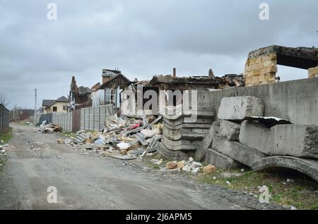 Dorf Dmytriwka, Region Kiew, Ukraine - 13. April 2022: Zerstörte Privathäuser während aktiver Feindseligkeiten in der Ukraine. Krieg Russlands gegen die Ukraine Stockfoto