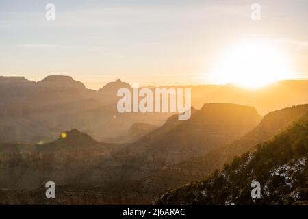 Helle Sonne über dem Rand des Grand Canyon bei Sonnenaufgang entlang des South Kaibab Trail Stockfoto