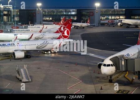Nachtansicht des Istanbuler Flughafens mit geparktem Airbus-Flugzeug durch das Torfenster Stockfoto