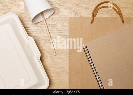 Umweltfreundliches Konzept, Lebensmittelbox Pappbecher Papiertasche und Notebook aus Naturfaser. Stockfoto