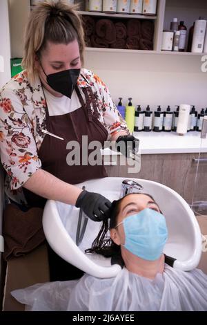 Friseur Anwendung lila Färbung Shampoo nach dem Färben der Haare. Stockfoto