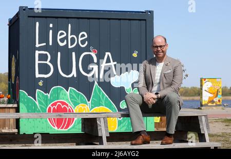 PRODUKTION - 25. April 2022, Mecklenburg-Vorpommern, Rostock: Oliver Fudickar, Geschäftsführer der BUGA Rostock 2025 GmbH, sitzt im Stadthafen an der Warnow vor den Buga-Containern, wo Informationen über die Bundesgartenschau zur Verfügung gestellt werden sollen. Die Buga 2025 in Rostock hat mit einigen Schwierigkeiten zu kämpfen, mehrere geplante Großprojekte können wahrscheinlich nicht rechtzeitig abgeschlossen werden. Foto: Bernd Wüstneck/dpa Stockfoto