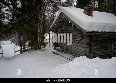 Rovaniemi, Finnland - 18.. März 2022: Ein Holzschuppen in einem verschneiten Tannenwald in Finnland. Stockfoto