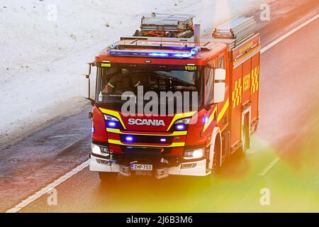 Scania P CrewCab Feuerwehrauto auf Abruf mit blauen Lichtern blinkend, mit Geschwindigkeit auf der Autobahn im Winter, hinzugefügt Flamme. Salo, Finnland. 31. Dezember 2021. Stockfoto