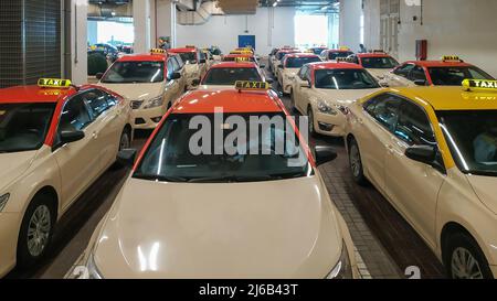 Dubai, VAE, 20. August 2019. Mani-Taxiwagen parkten in der Nähe eines Einkaufszentrums. Dubai öffentliche Verkehrsmittel. Viele Taxiwagen stehen auf einem Parkplatz in Reihen. Stockfoto