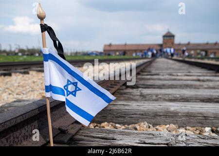 Eine israelische Flagge, die auf den Eisenbahnschienen in KL Birkenau während des Internationalen Marsches der Lebenden gesehen wurde. Internationaler Marsch der Lebenden vom KL Auschwitz nach KL2 Birkenau. Über 3000 Juden aus der ganzen Welt kamen nach Oswiecim, um am Internationalen Marsch der Lebenden teilzunehmen. Es ist ein Gedenken an die Opfer des Holocaust. Der polnische Präsident Andrzej Duda nahm an dieser Veranstaltung Teil. Stockfoto