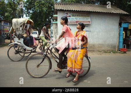 Frauen auf dem Fahrrad in Tamluk, Purba Medinipur, Westbengalen, Indien. Stockfoto