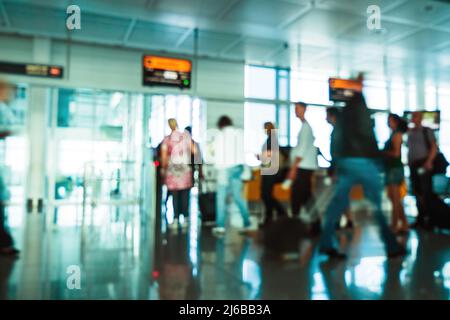 Unscharfe Silhouetten von Pendlern in Side International Airport Gate-Leuten, die ein kleines Handgepäck mit sich führen und ins Flugzeug einsteigen Stockfoto