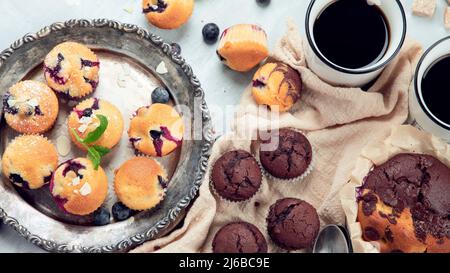 Muffins Sortiment auf hellem Hintergrund. Frisch gebackene Cupcakes. Konzept der Feier. Draufsicht, flach liegend Stockfoto