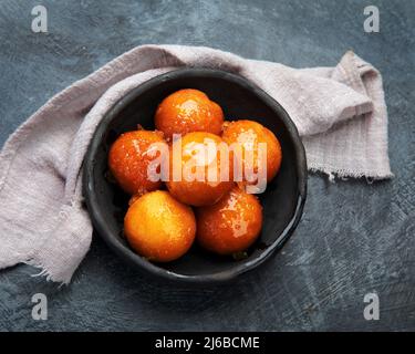 Gulab Jamun auf grauem Hintergrund. Traditionelles orientalisches Speisekonzept. Süße indische Snacks. Draufsicht, flach liegend Stockfoto