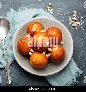 Gulab Jamun auf grauem Hintergrund. Traditionelles orientalisches Speisekonzept. Süße indische Snacks. Draufsicht, flach liegend Stockfoto