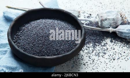 Zusammensetzung mit Mohnsamen auf grauem Hintergrund. Bio-Food-Konzept. Stockfoto