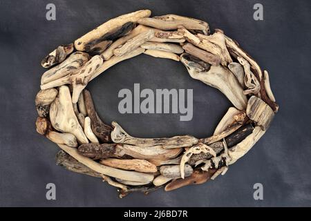 Driftwood Kranz rustikal oval geformt. Natürliche abstrakte Strandkunst Naturkomposition mit Kopierraum auf grauem Hintergrund, Draufsicht, flach liegend. Stockfoto