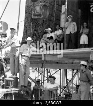 Regisseur HOWARD HAWKS am Drehort offen mit Movie Crew in Ägypten während der Dreharbeiten zum LAND DER PHARAONEN 1955 Regisseur / Produzent HOWARD HAWKS Schriftsteller William Faulkner Harry Kurnitz und Harold Jack Bloom Musik Dimitri Tiomkin Continental Company / Warner Bros. Stockfoto