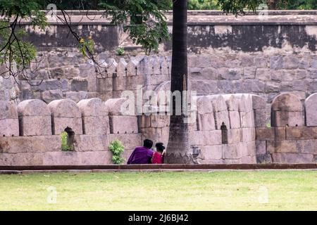 Vellore, Tamil Nadu, Indien - September 2018: Ein indisches romantisches Paar, das unter einem Baum im Park von Vellore Fort sitzt. Stockfoto